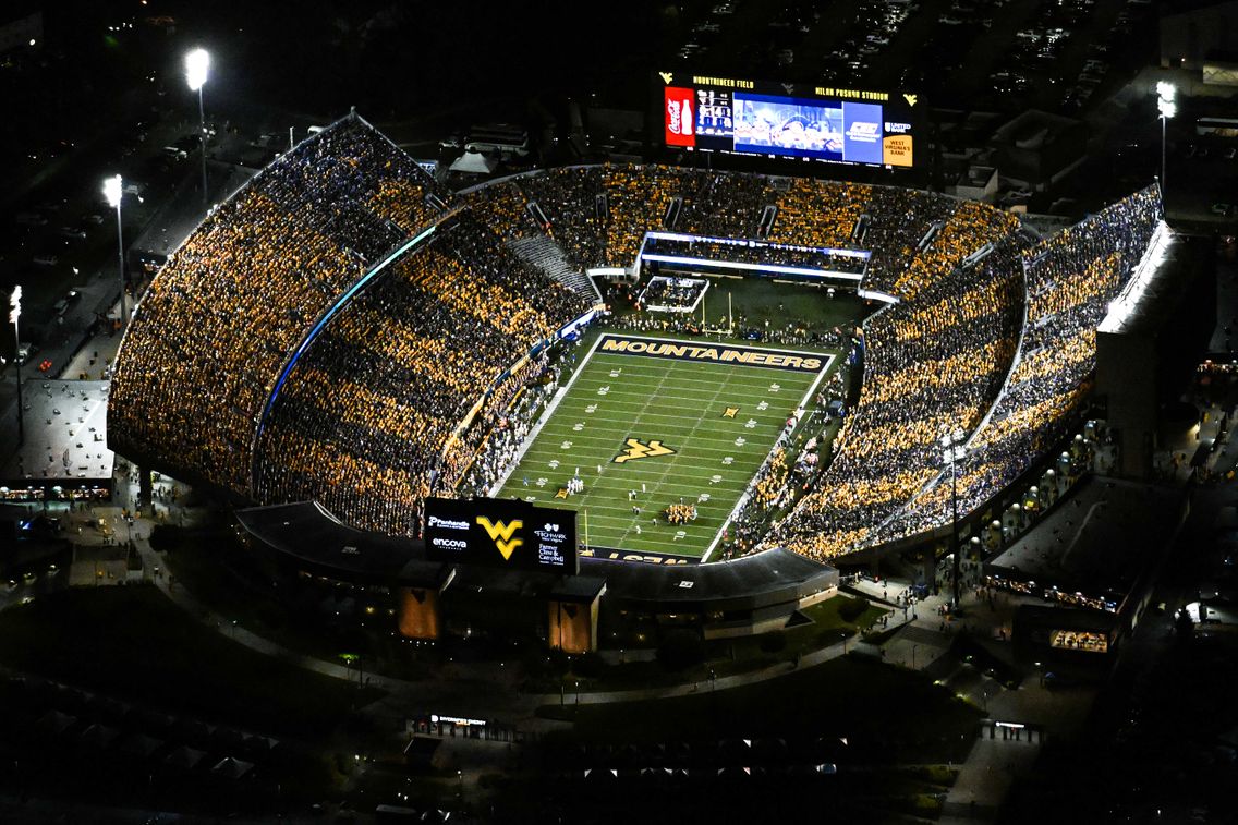 Aerial view of Milan Puskar Stadium packed with a sold-out crowd. Sections alternate gold and blue to stripe the stadium.
