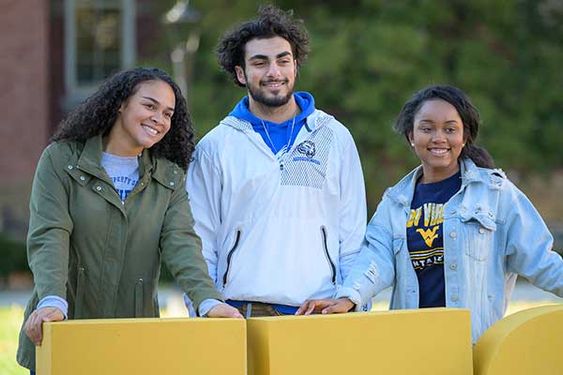 Three students pose for a picture in Woodburn Circle